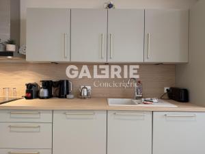 a kitchen with white cabinets and a sink at GC - Le Caps des Dunes - Centre in Wissant +6 photos