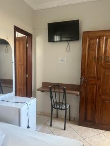 a room with a desk and a chair and a television at Hotel Pará Santarém PA in Santarém