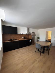 a kitchen with a table and a kitchen with a sink at Le Comptoir du Relais in Beine