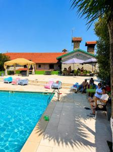 a group of people sitting around a swimming pool at Casa Augusta - QUINTA in Penafiel