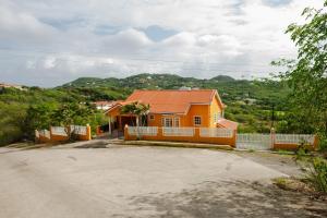 a orange house with a white fence and a driveway at Cap Estate Ocean View Villa, Gros Islet, St Lucia in Dame de Traversay