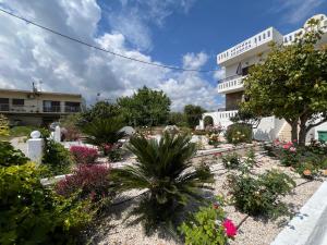 a garden in front of a building with flowers at Zourpos Studios in Kalyves