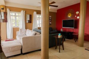 a living room with a couch and a tv at Cap Estate Ocean View Villa, Gros Islet, St Lucia in Dame de Traversay