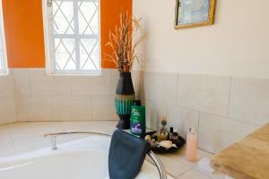 a bathroom with a tub and a chair and a sink at Cap Estate Ocean View Villa, Gros Islet, St Lucia in Dame de Traversay +13 photos