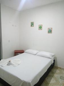 a bed in a room with two pictures on the wall at La Quinta INN in Santa Marta +22 photos