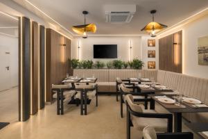 a restaurant with tables and chairs and a flat screen tv at Heritage Hotel Ames in Poreč