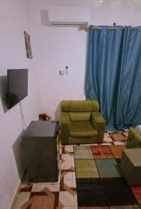 a living room with a green couch and a television at Master Home in Baatsona