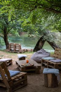 a picnic area with tables and benches and a river at Divlji Mir in Dobro Polje