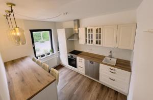 a kitchen with white cabinets and a wooden floor at Cosy Place Xanten in Xanten