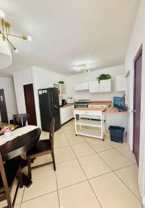 a kitchen and dining room with a table and a refrigerator at Casa en grupo, terraza y alberca compartida in Mexicali