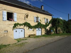 a large brick building with white doors and a window at Au Lou Pélélée in Madranges