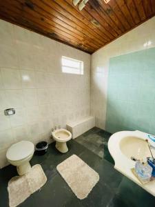 a bathroom with a toilet and a bidet and a sink at Pousada Canastra Raíz in Delfinópolis +26 photos
