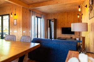 a living room with a blue couch and a table at Gîte de la Bridolée, sauna et bain nordique in Lorquin