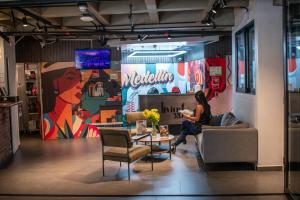 a woman sitting on a couch in a room at Hotel Living 35 Suites by Growing Group in Medellín