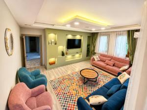 a living room with a couch and chairs and a tv at Auga Apart in Uzungöl