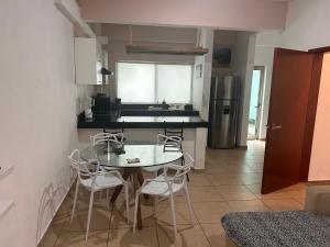 a kitchen with a table and chairs in a kitchen at Paraíso maya apartaments in Playa del Carmen