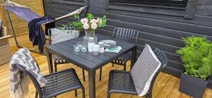 a black table with chairs and a vase of flowers at Lösen Retreat in Lyckeby +15 photos