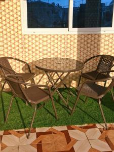 a table and four chairs and a glass table and chairs at Master Home in Baatsona