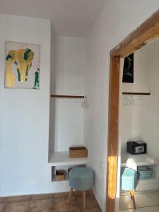 a room with a white wall with a blue stool at 7Olives Azure Boutique Apartment in Kastraki