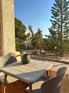 a table and chairs on a patio with a tree at 7Olives Azure Boutique Apartment in Kastraki