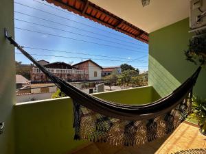 a hammock on a balcony with a green wall at Chico de Sá Pousada in Pirenópolis