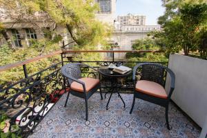 eine Terrasse mit zwei Stühlen und einem Tisch auf einem Balkon in der Unterkunft ZM hotel in Baku