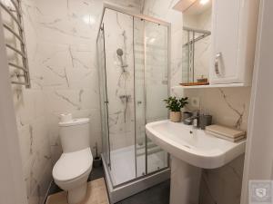 a white bathroom with a toilet and a sink at RentHouse Apartments-Old Town Studio #2 in Chişinău