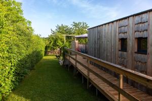 a house with a wooden deck next to a building at Gîte de la Bridolée, sauna et bain nordique in Lorquin