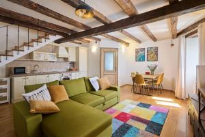 a living room with a green couch and a table at Casa Gina in Grožnjan