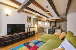 a living room with a green couch and a flat screen tv at Casa Gina in Grožnjan