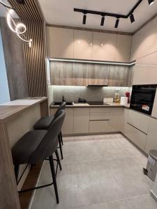 a kitchen with a counter and some chairs in it at Apartman NOVA in Kragujevac +1 photo