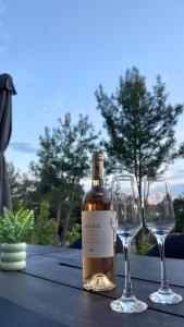 a bottle of wine and two wine glasses on a table at Ammos Maisonettes in Pefkari