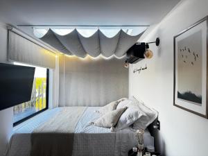 a bedroom with a bed with a window and a tv at Refúgio do Lago in Linhares