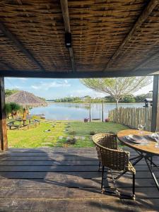 a patio with a table and chairs and a view of a lake at Refúgio do Lago in Linhares