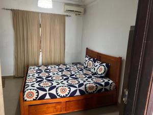 a bedroom with a bed with a floral comforter and pillows at The Senegambia Hideaway in Amdalai +27 photos