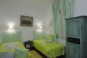 a bedroom with two twin beds and a cabinet at Hôtel Restaurant L'Aiglon in Zonza