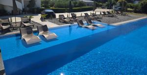 a swimming pool with lounge chairs and blue water at Casa Lu in Ulcinj
