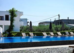 a swimming pool with lounge chairs and umbrellas at Casa Lu in Ulcinj