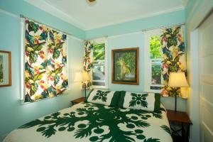 una camera da letto con un letto e due finestre di Iao Valley Inn a Wailuku
