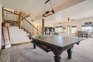 a living room with a ping pong table and stairs at Mountain Retreat - Deck Views - Sleeps 10 in Black Hawk