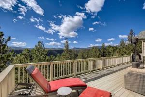 a deck with a red reclining chair and a view of the mountains at Mountain Retreat - Deck Views - Sleeps 10 in Black Hawk