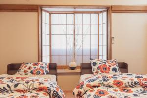 a bedroom with two beds and a window at 民泊八のや in Hachioji