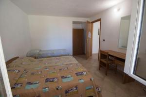 a bedroom with a bed and a desk in it at Fondaco del Capo in Capo Vaticano