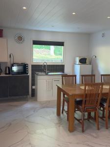 a kitchen with a wooden table and chairs and a sink at Guest house in Lyckeby in Karlskrona