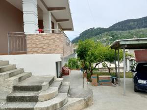 a house with stairs and a car parked next to it at ArsonGuest in Berat