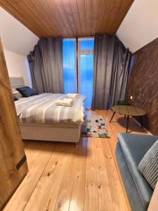 a bedroom with a bed and a large window at Petar in Kamešnica