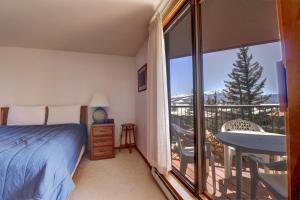 a bedroom with a bed and a balcony with a table at 432 Marina Place in Dillon
