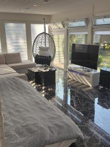 a living room with a television and a couch at Guest house in Lyckeby in Karlskrona