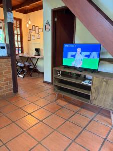 a flat screen tv sitting on top of a cabinet at Chalé Lumiar M&C in Lumiar