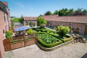 an outdoor garden with a table and an umbrella at La Ferme Des Eglantines in Nivelles